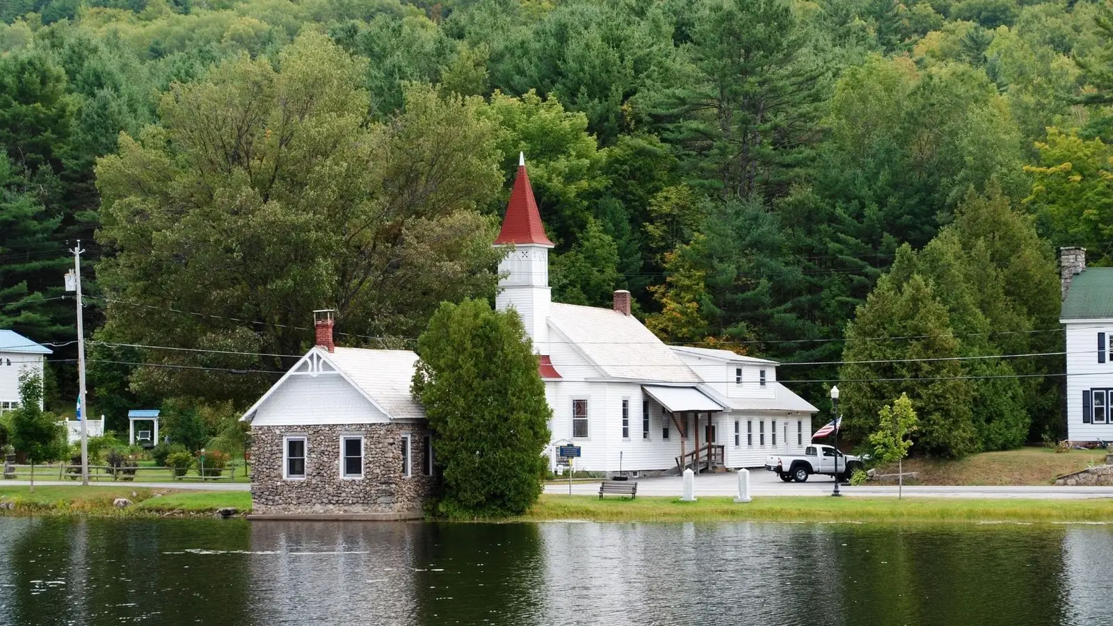 Horicon Baptist Church beside the Mill Pond, with the Adirondack hills behind