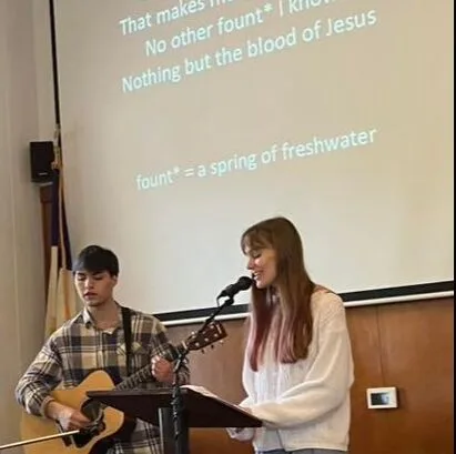 Musicians leading worship with guitar and vocals at HBC